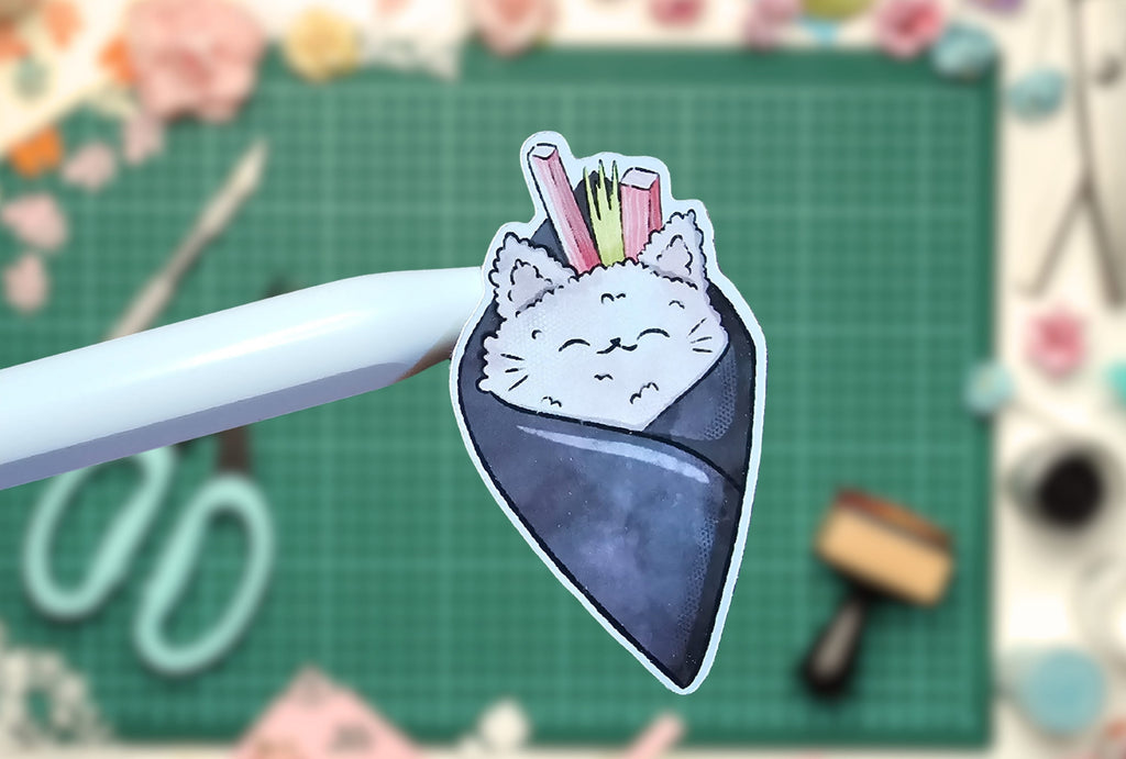 Cat-themed sushi patch on a cutting mat with tools in the background