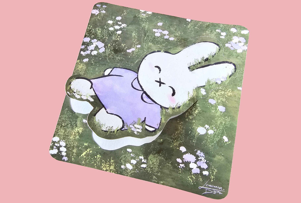 A square mousepad with rounded corners featuring a cartoon rabbit illustration, shown at an angle against a solid pink background. The mousepad has a green and brown textured background with small white flowers, and the rabbit is white with a purple shirt.