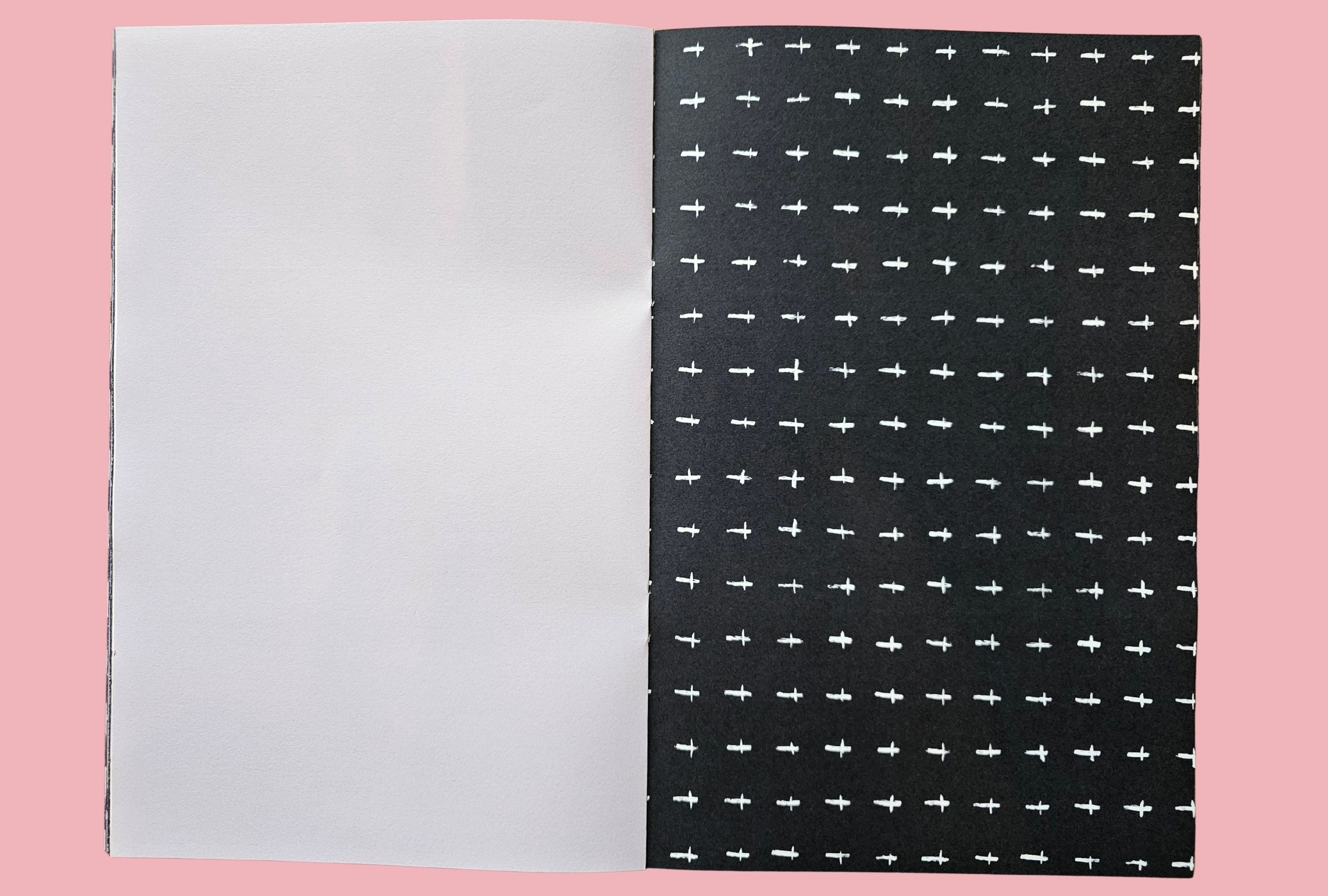 Black paper with white cross pattern on a pink background