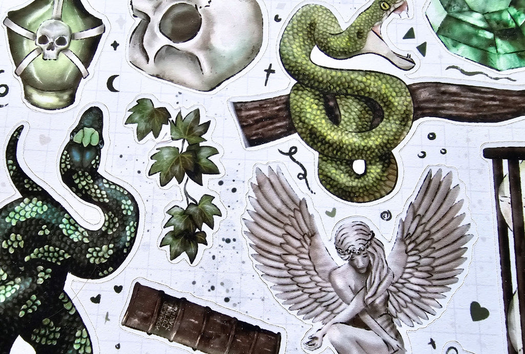Collection of decorative elements including snakes, skulls, and wings on a white background.