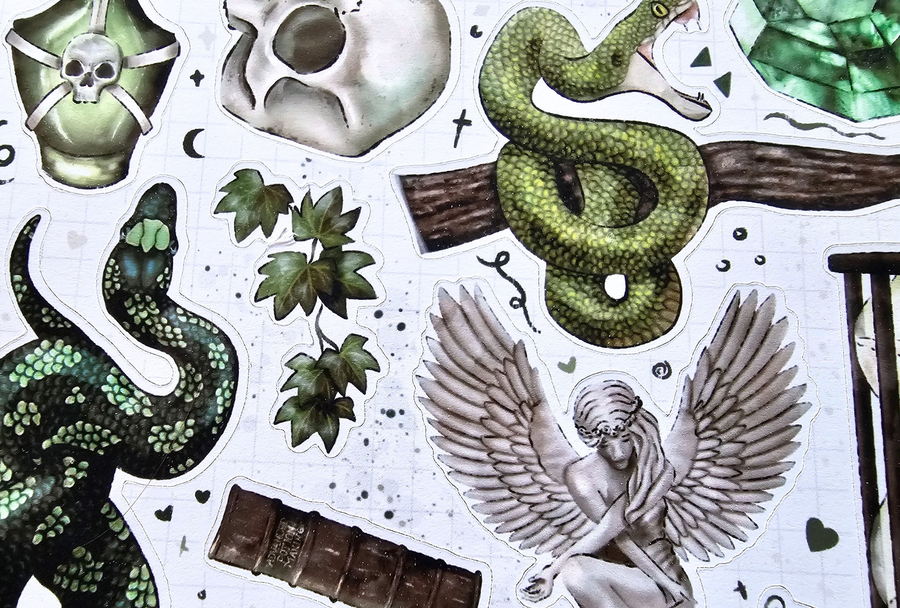 Collection of decorative elements including snakes, skulls, and wings on a white background.