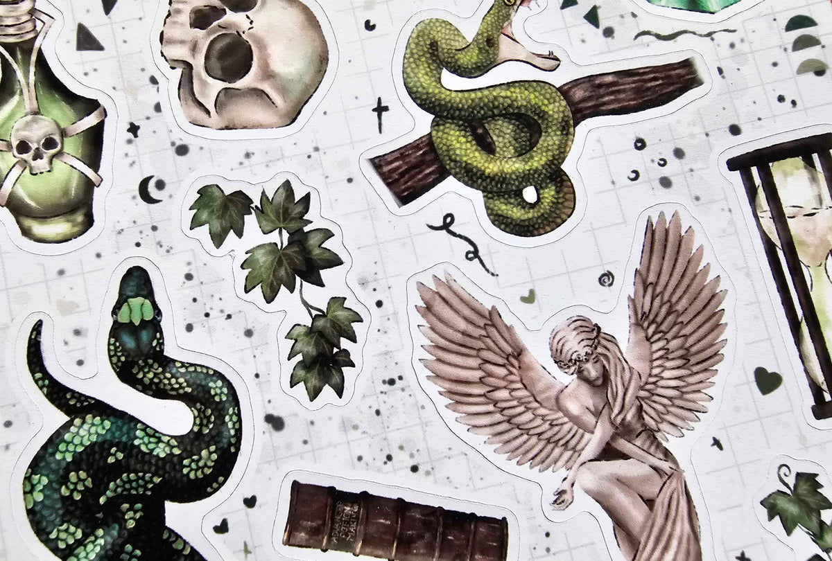 A collection of gothic and occult-themed stickers arranged on a white grid background, featuring illustrations of a green snake, a winged angel, a skull, a potion bottle with a skull crossbones, green leaves, and a book.