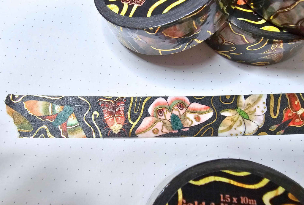 close up of a washi tape with illustrated moths and gold foil details