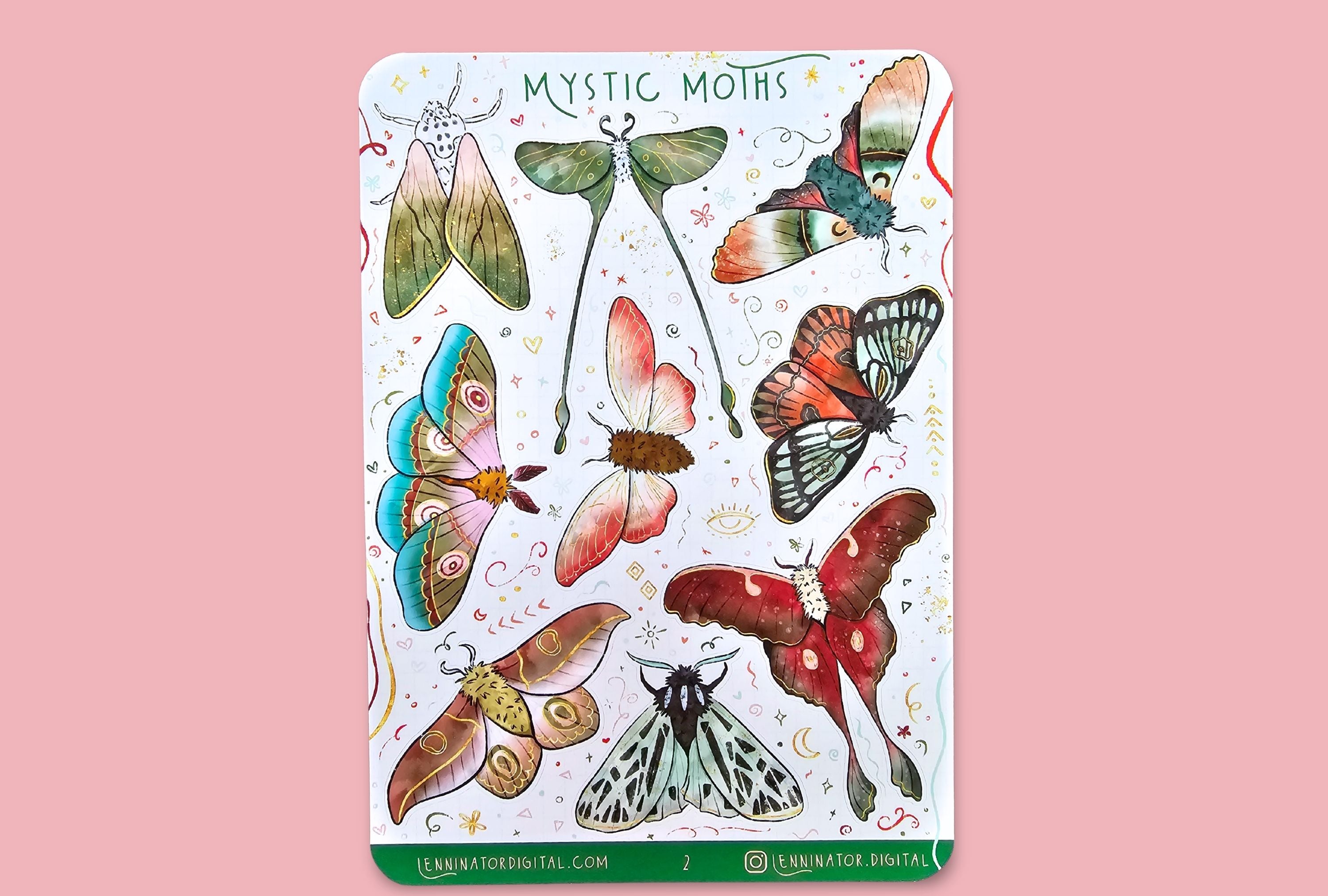 Sheet of 'Mystic Moths' stickers on a wooden surface with flowers.