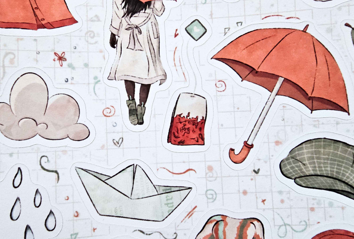 A close-up of a white sticker sheet featuring watercolor-style illustrations of an orange umbrella, clouds, raindrops, a paper boat, a girl in a white coat, and other small autumn-themed motifs on a light grid background.