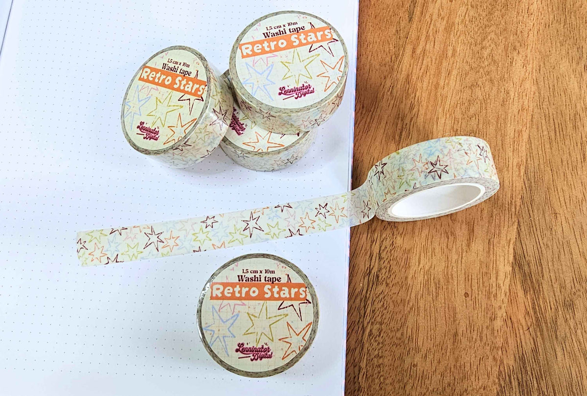 Washi tapes of retro stars and a washi tape roll stuck on a piece of journal paper with a pattern of various retro stars.