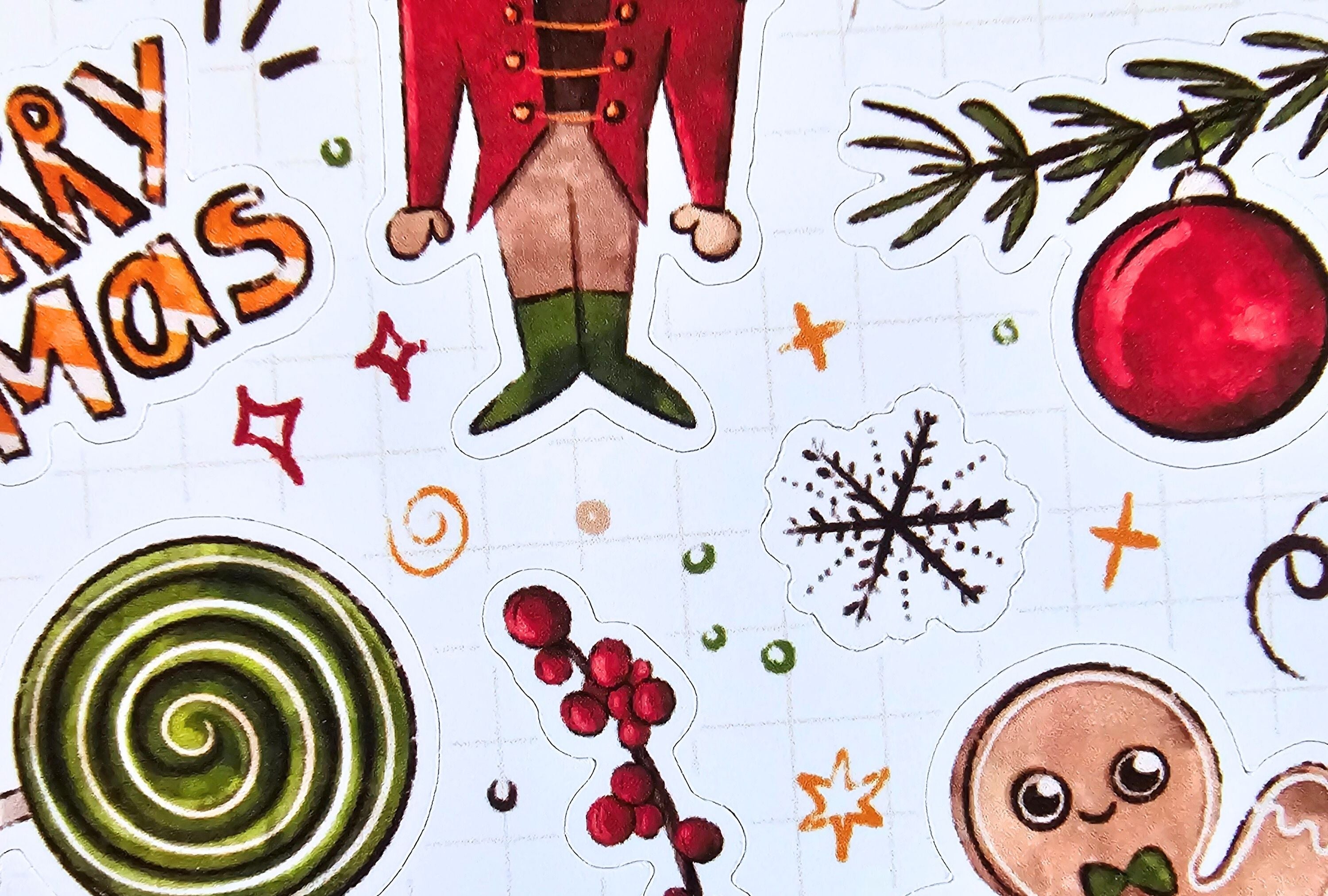 Collection of Christmas-themed stickers including a gingerbread man, candy cane, and ornaments on a white background.