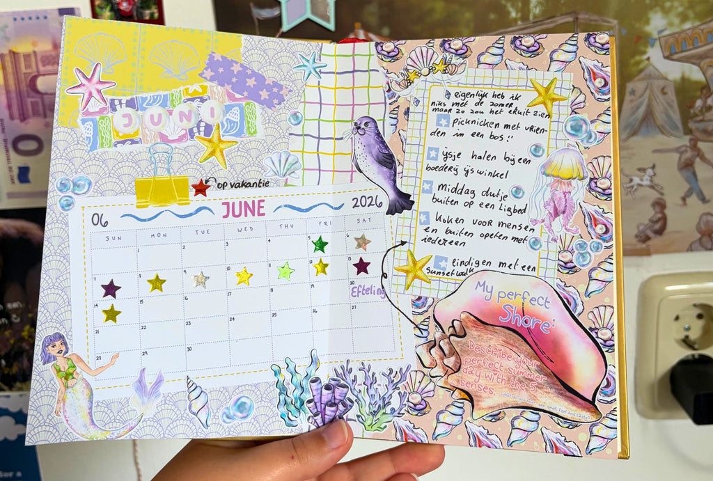 Decorative planner with mermaid theme held by a person