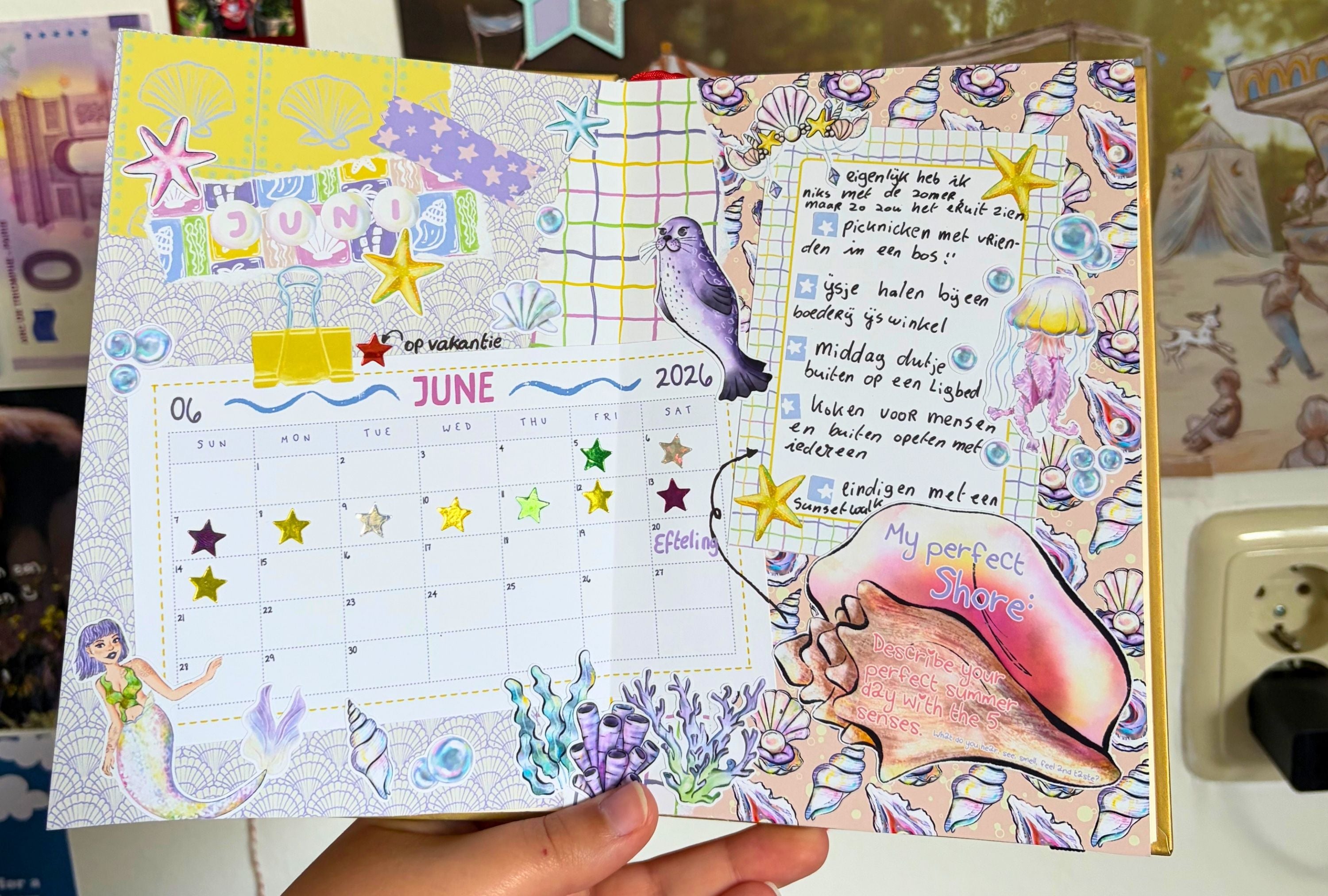 Decorative planner with mermaid theme held by a person
