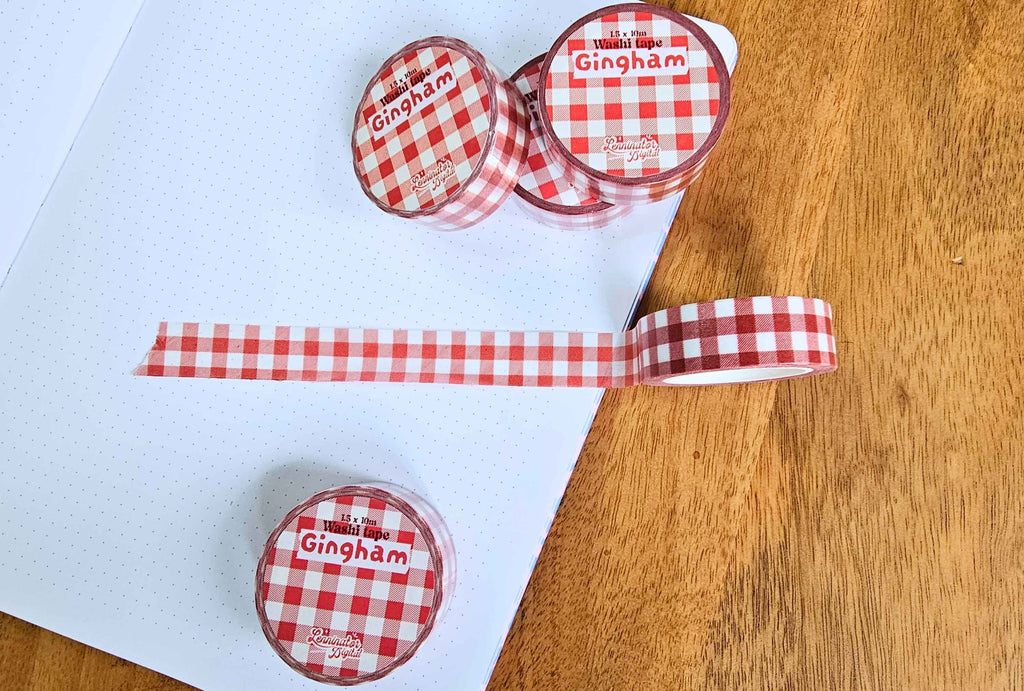 rolls of red gingham washi tapes and a washi tape stuck on paper with red and white checkered pattern.